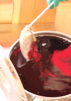 濾しあがった赤シソエキスは丁寧に灰汁を取ります